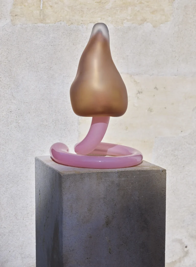 Sluren Table Lamp in dusty pink and transparent glass on a plinth, angled view.