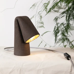 Melo Fol Table Lamp in Ceramic on beige fabric, leaves in the background