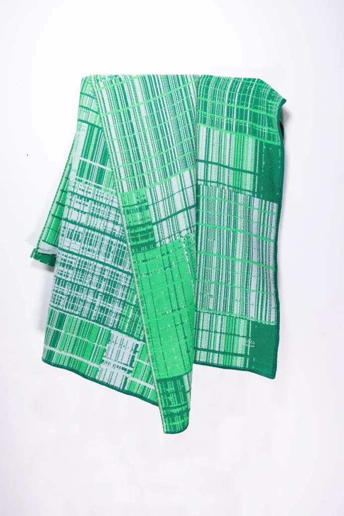 Graphic jacquard blanket in emerald by Emma Terweduwe, draped
