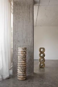Antigua and Roma stone totems in banded marble and onyx in a concrete-walled studio by Studio Ayres