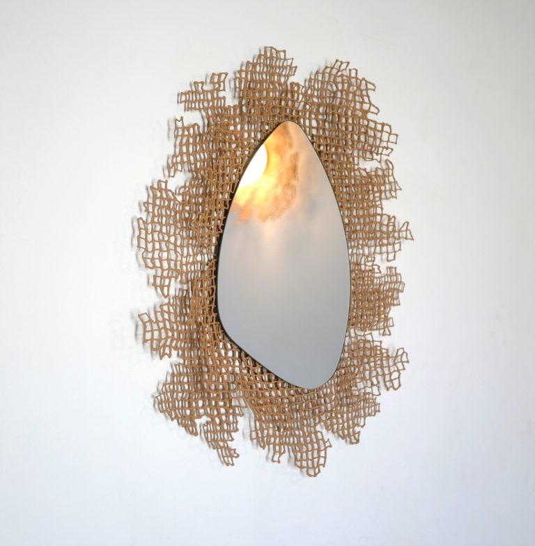 Coral Mirror by Dzovag Kotchian, medium size, seen from the side with a warm glow reflected in the mirror