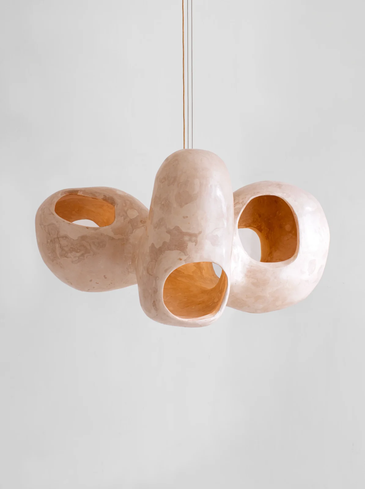 Bosei oversized handmade gypsum chandelier with cutouts revealing golden tones by Studio AOAO