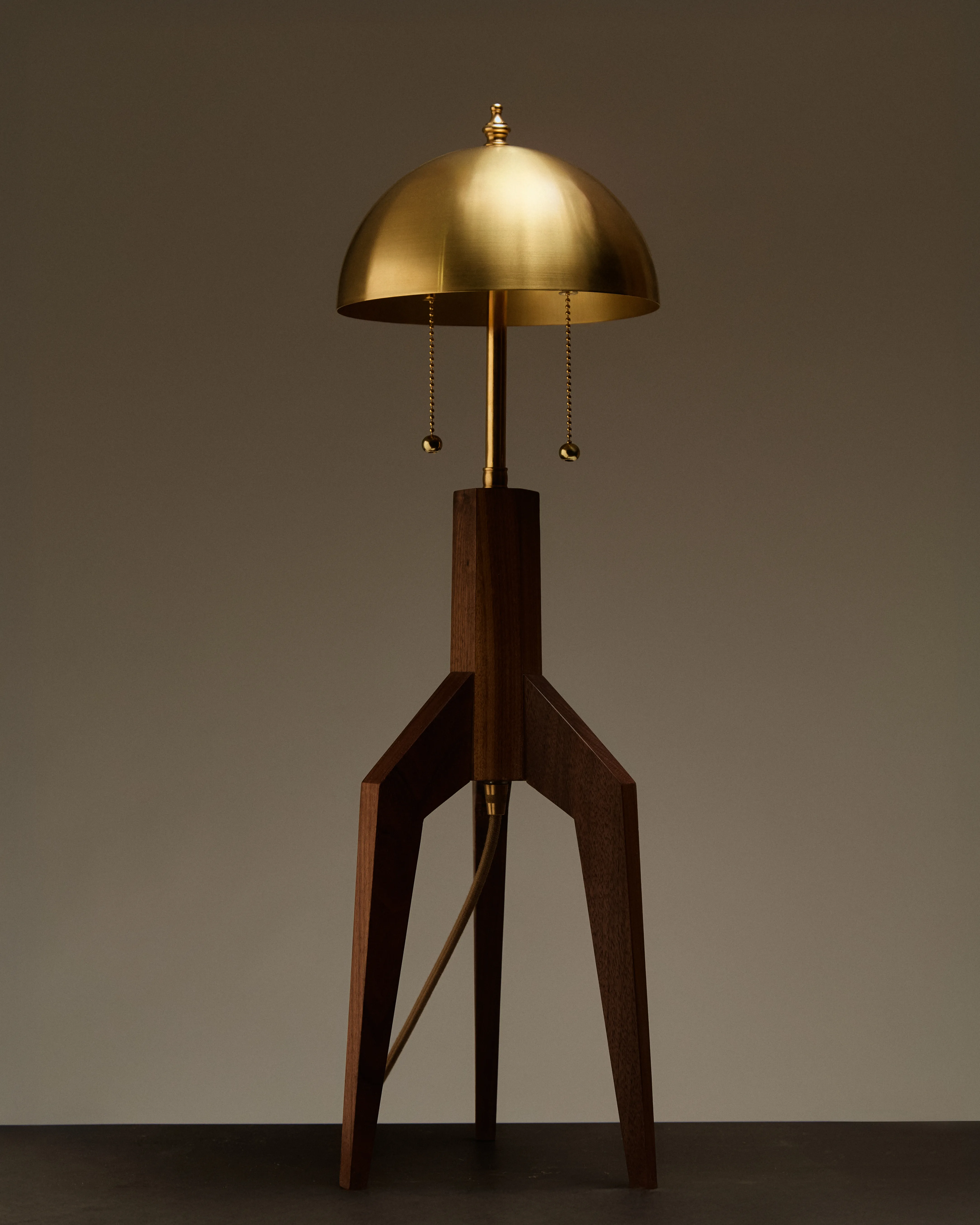 Falcon table lamp with a rocket-shaped walnut base and spun brass shade by Nathan Chintala