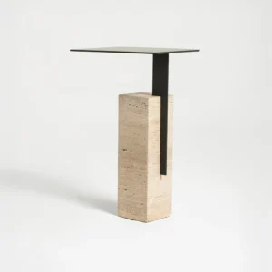 Mono pedestal side table with a thick travertine base and thin metal top by Yet Design Studio