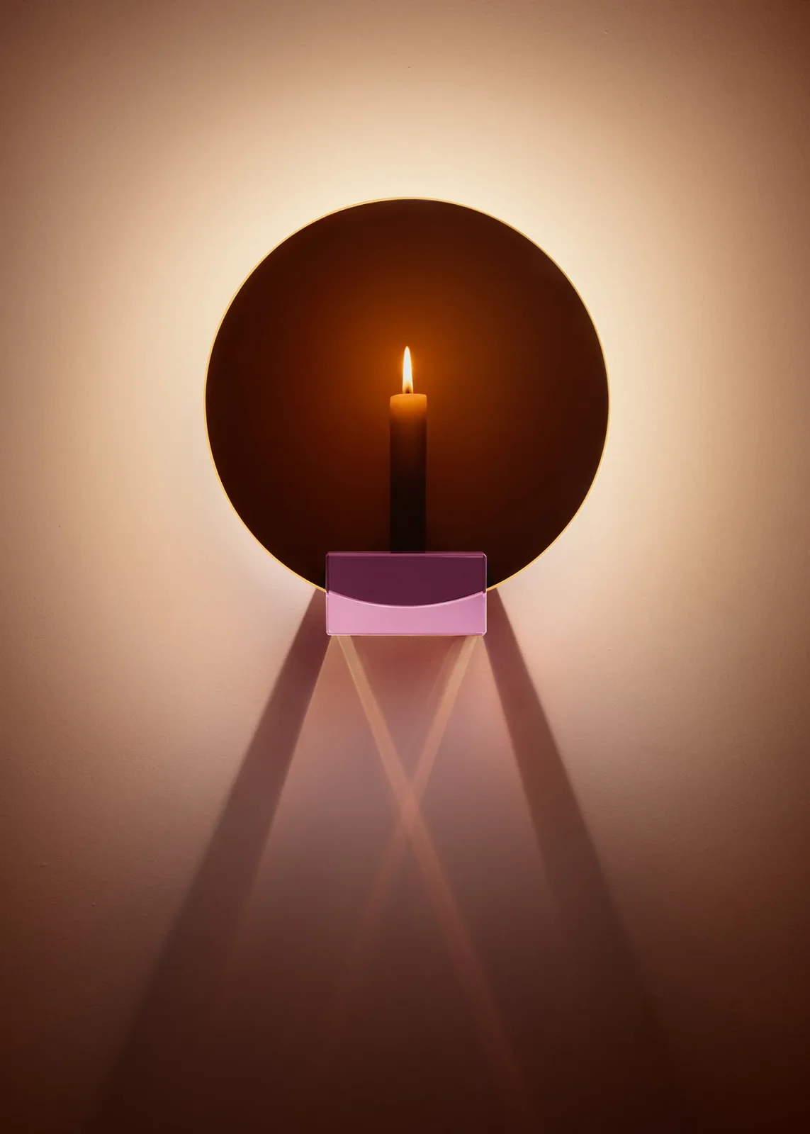 Spegla Wall Edition round mirror with a pink crystal glass candle holder glowing with a lit candle by Jochen Lavéno Mangelsdorff
