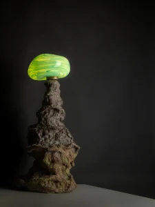 Abyss No. 31 Table Lamp in dark stoneware with hand-blown glass, on a table, front view. Abyss No. 31 dark stoneware table lamp with hand-blown glass by maiizen