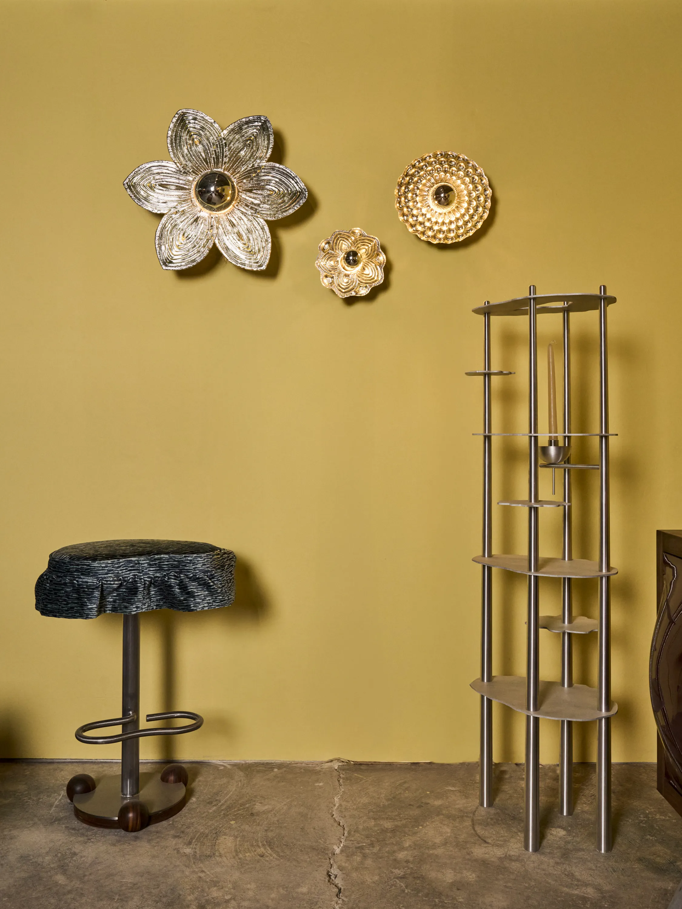 Dahlia Blossom flower-shaped blown glass wall sconce hanging on a yellow wall beside smaller glass sconces by Toro Manifesto