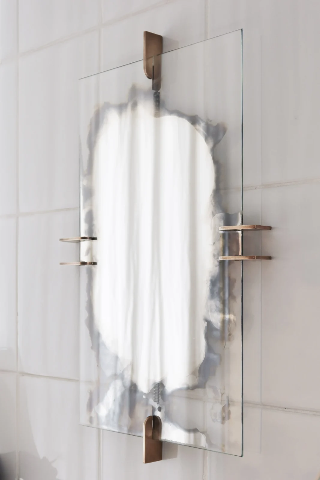 Umbra wall mirror with patinated brass holders and steel springs by Hasik Design