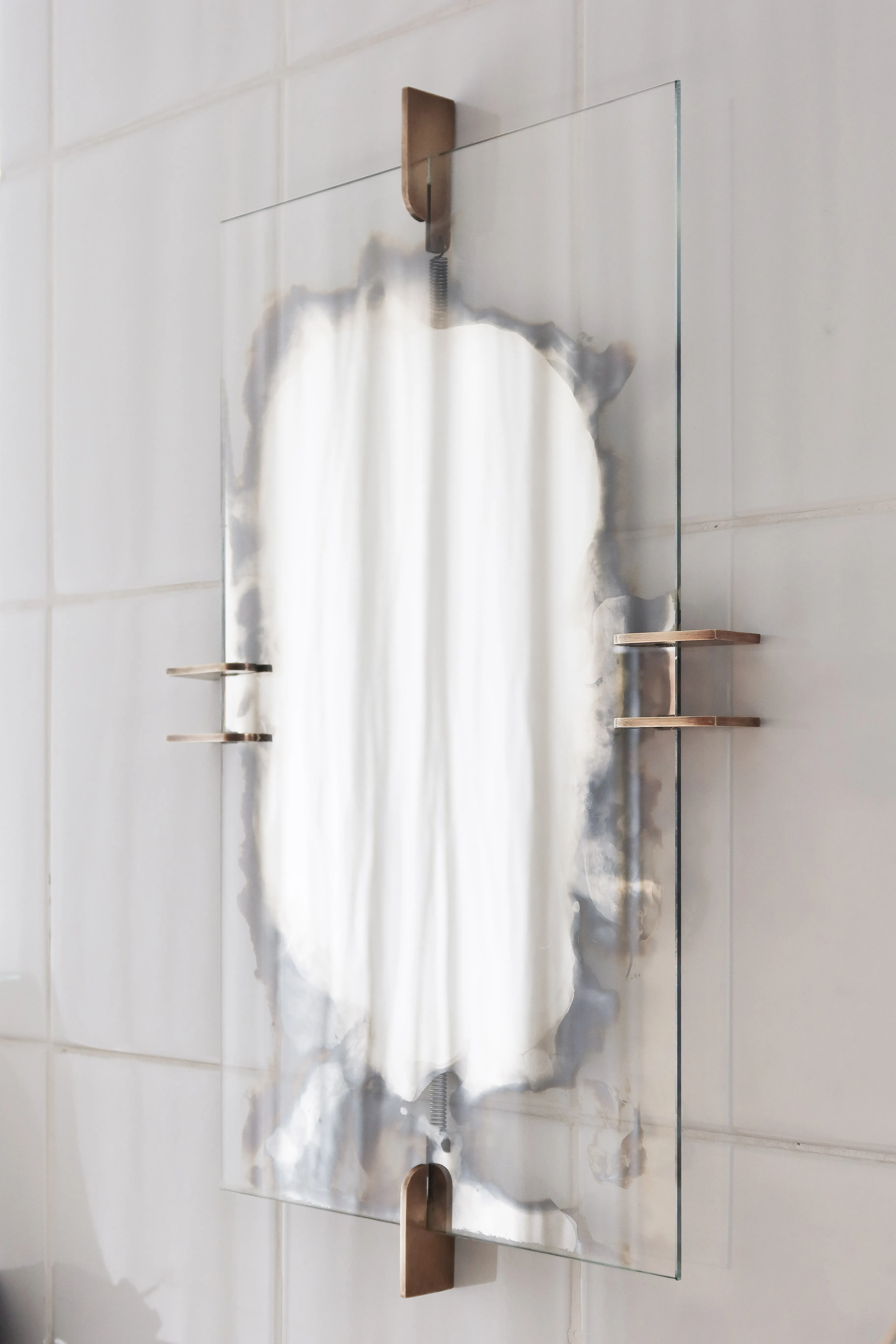 Umbra wall mirror in patinated brass