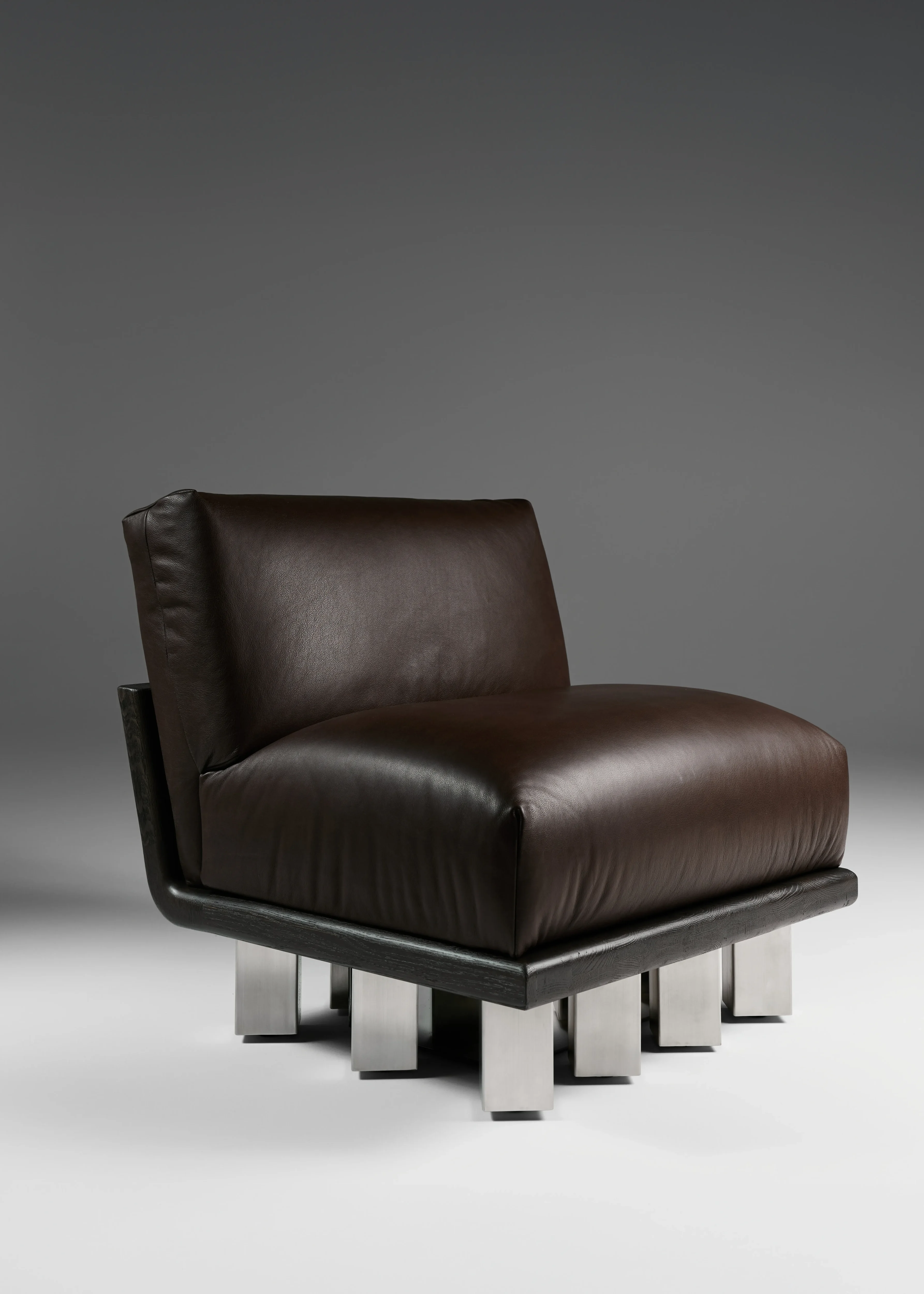 Kafka Lounge Chair with upholstered volume above grid of metal columns