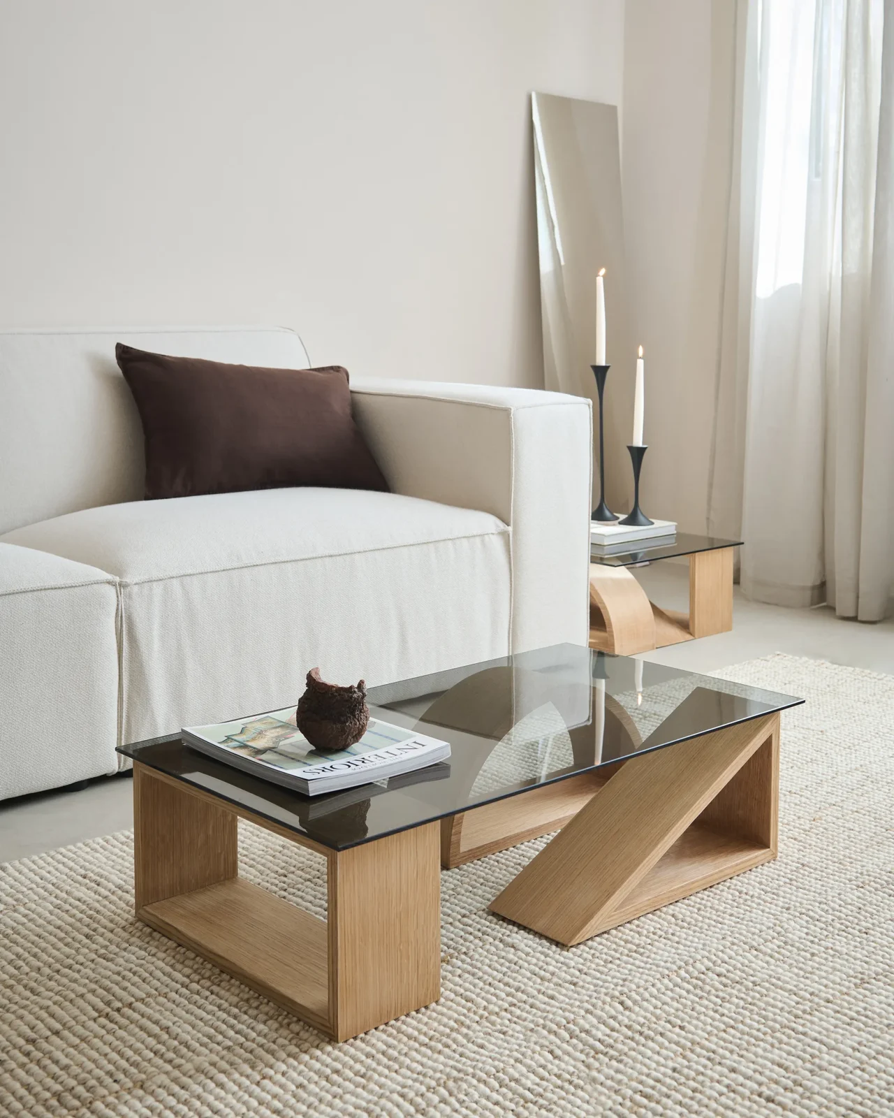 Formation coffee table by Theodora Alfredsdottir with oak-veneer shapes beneath a smoky glass top, in a styled room