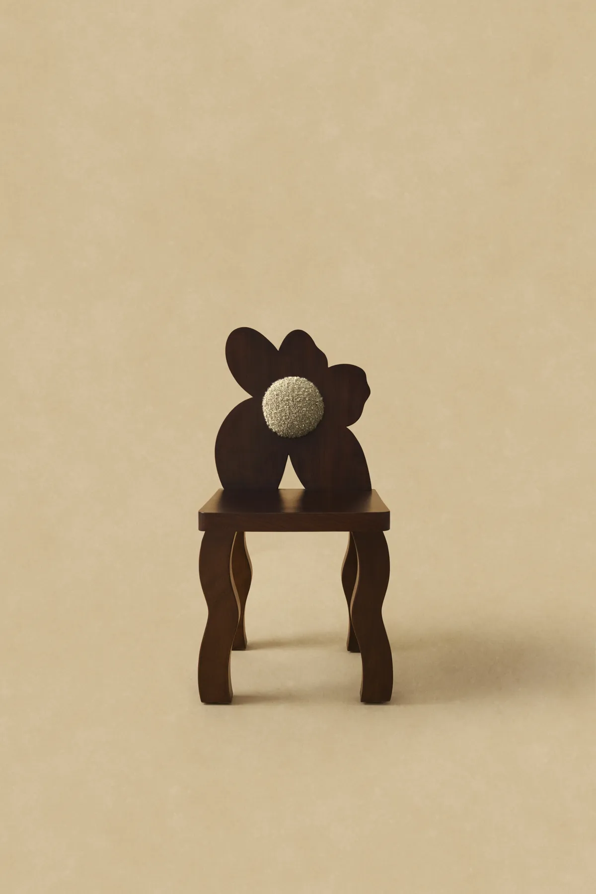 Poppy chair in dark oak with a flower-shaped backrest, teddy-upholstered center and wavy legs by Deya