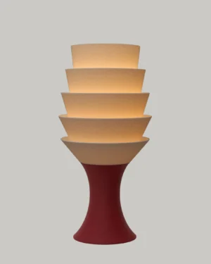 Empilé Petit Table Lamp in Jade White PLA with a Burgundy Red base, on a table.