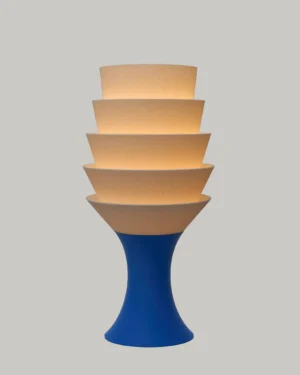 Empilé Petit Table Lamp in Jade White PLA with a Royal Blue base, on a table.