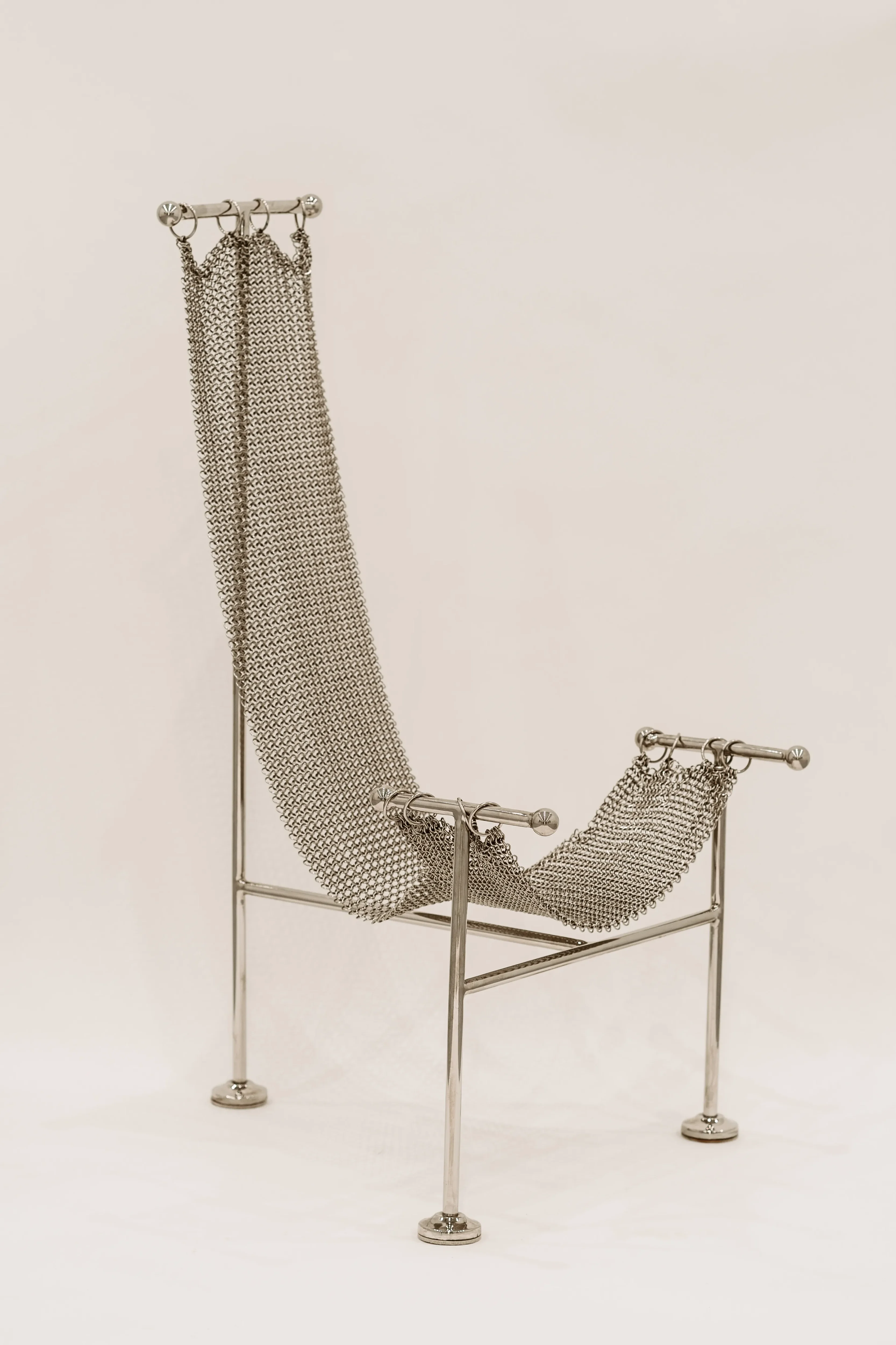 Chainmail chair with a seat of hand-linked nickel-plated metal rings draped from a steel T frame by Panorammma Atelier
