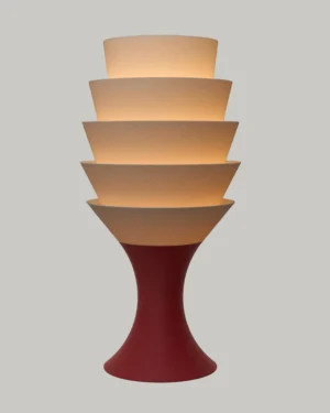 Empilé Grande Table Lamp in Jade White PLA with a Burgundy Red base, on a table.
