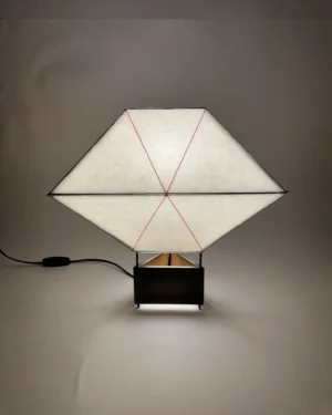 Biiit 005 Table Lamp in paper and brass on a table, front view.