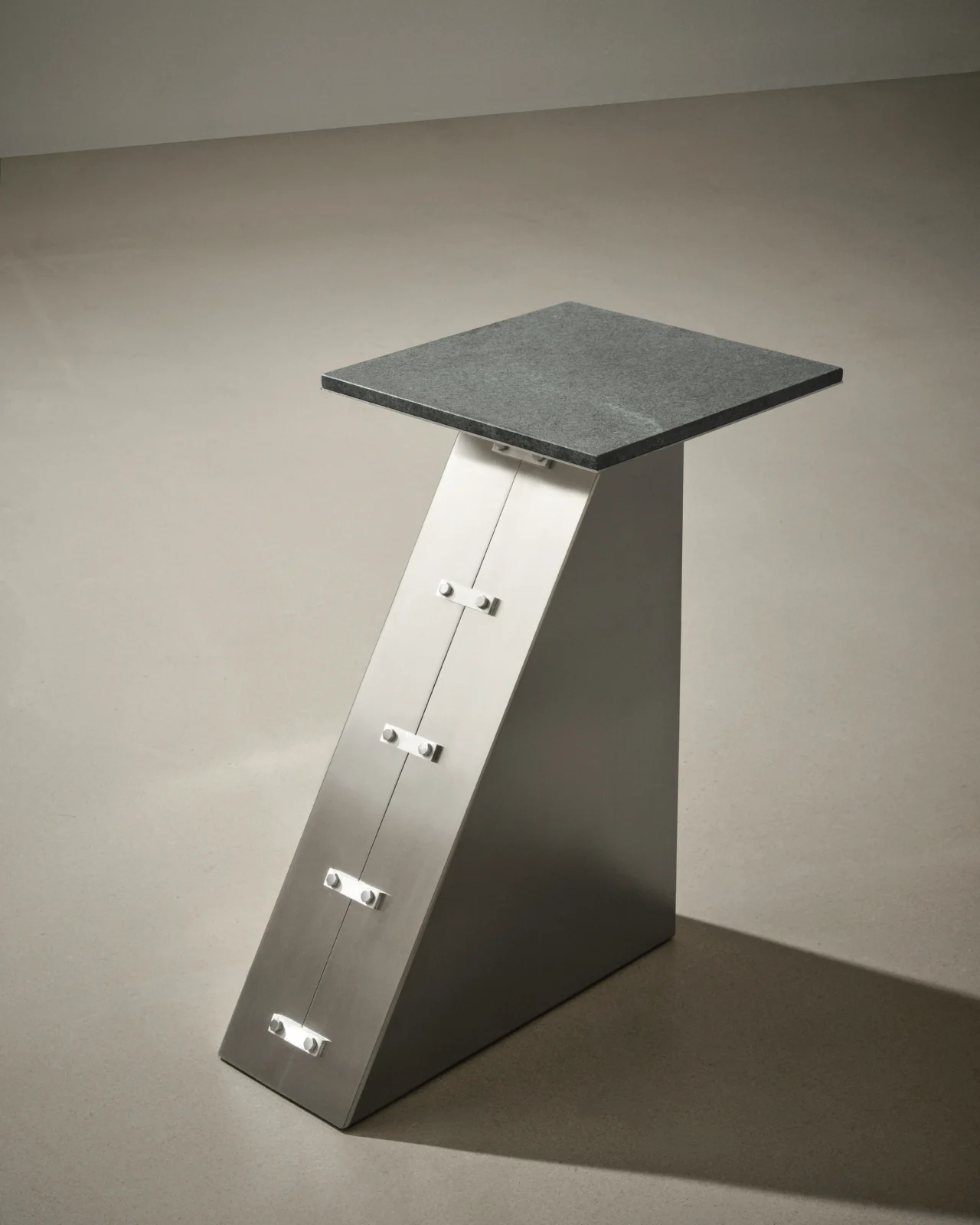 Coraza side table in bent stainless steel with a solid volcanic diabase top by Studio Mohs