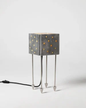 Prisma Massiva Table Lamp in cast aluminum, resin and steel, on a table.