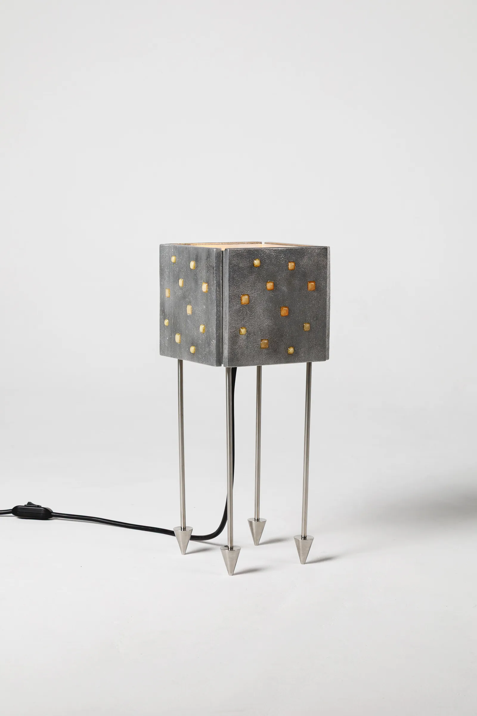 Prisma Massiva table lamp with a cast aluminum dome and amber resin on stainless steel legs by DONO Design