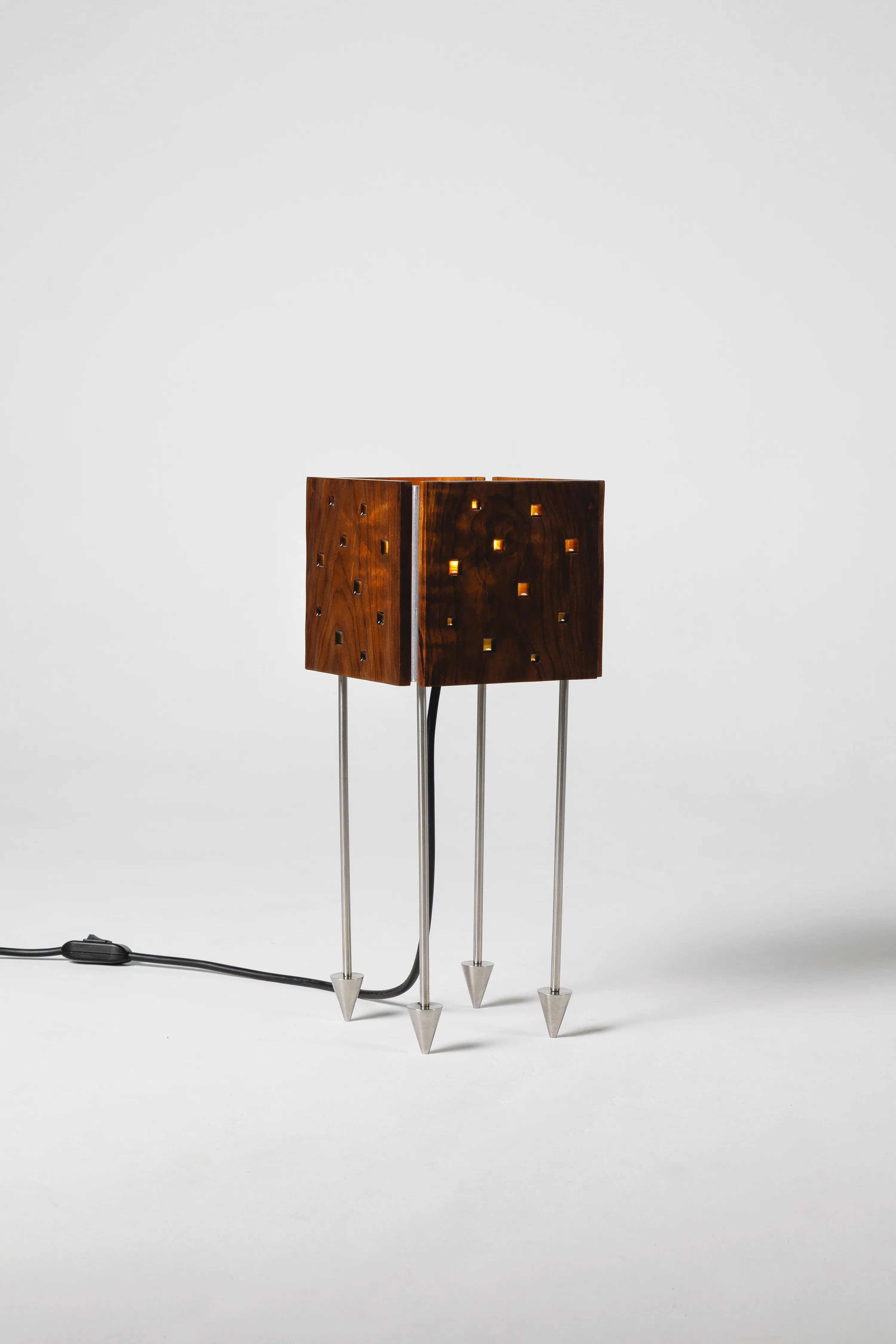 Prisma Massiva table lamp with a hand-textured imbuia wood dome and amber resin cut-outs on steel legs by DONO Design