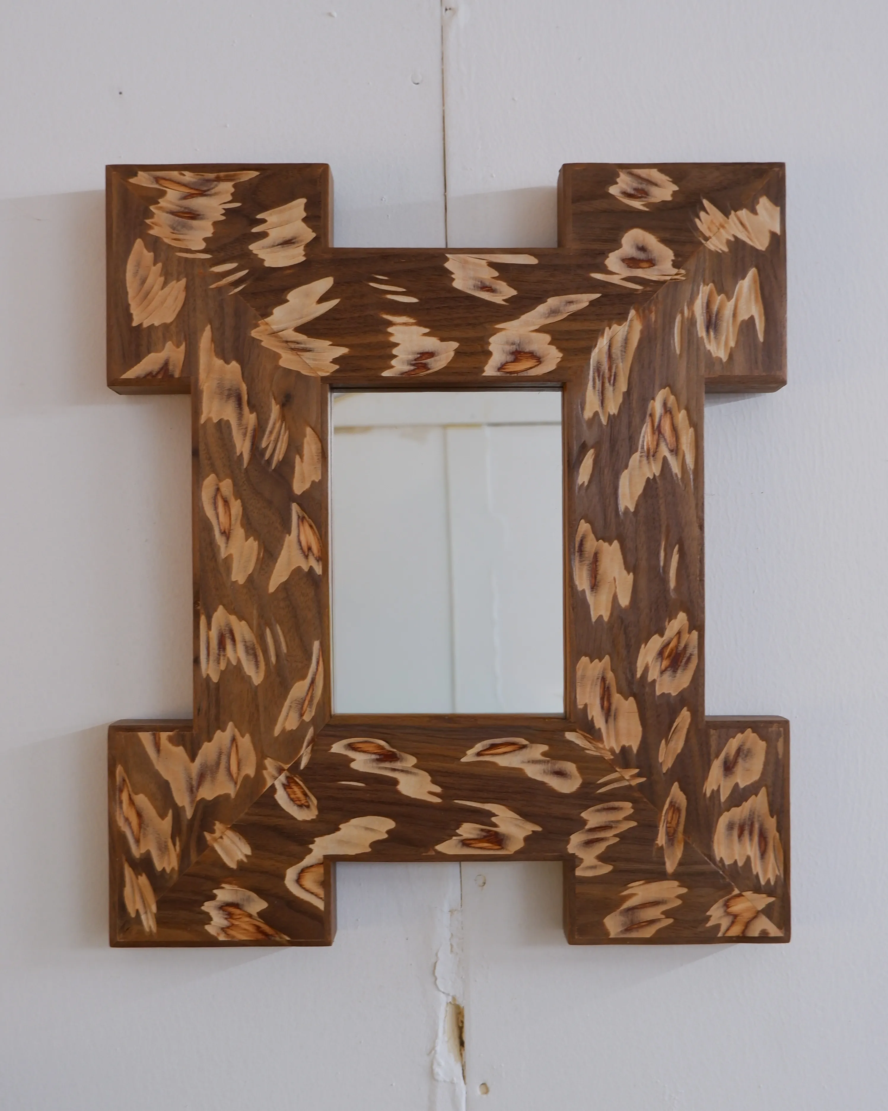 Acid wall mirror with a bold carved walnut frame and textured surface inspired by 18th-century picture frames by Josh Page Studio