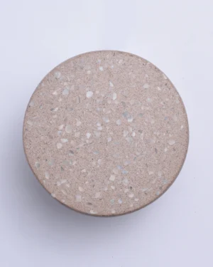 Wilo Nude Wall Sconce in beige speckled terrazzo on a wall, front view.