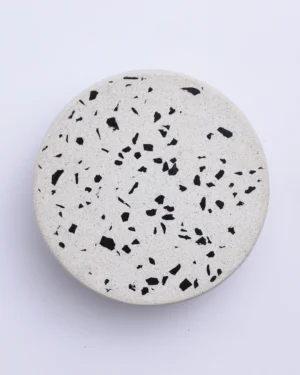 Wilo Mono Wall Sconce in black and white terrazzo on a wall, front view.