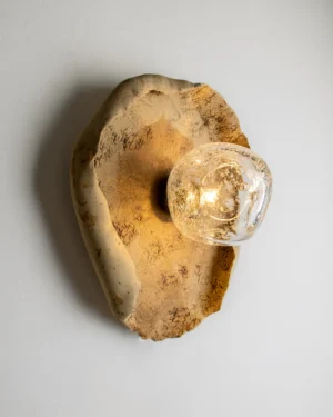 Asea No. 41 Wall Sconce in ochre stoneware with clear blown glass on a wall, front view.