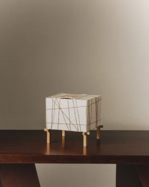 Fardo Table Lamp in white porcelain with rope lines on a wooden table, front view.