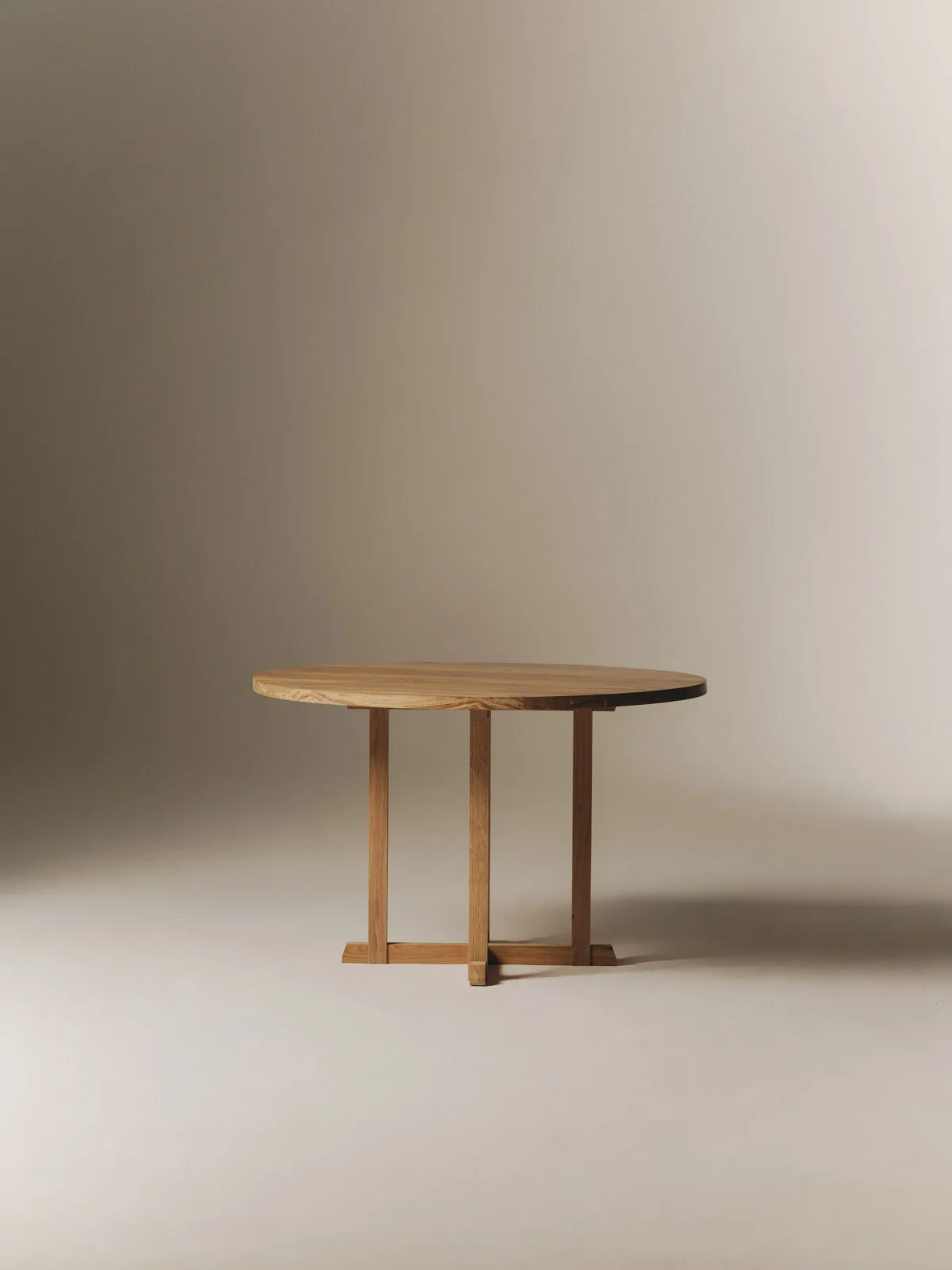 Nicola round dining table in solid oak with an intersecting trestle base by Mike Hausmann