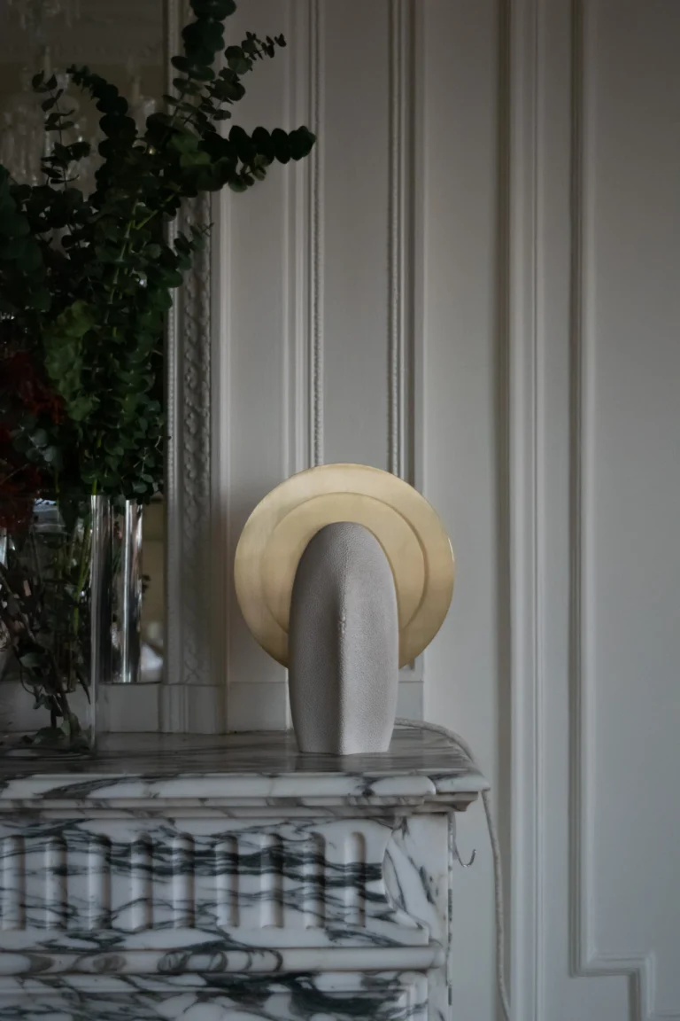 Mother of the Light Table Lamp by PALUCKI Studio in a paneled room, unlit on a marble mantel beside a vase of eucalyptus