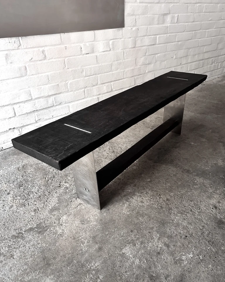 Blackwood Aluminium Bench by case studios seen from the side, showing both aluminum legs and the dark crossbar
