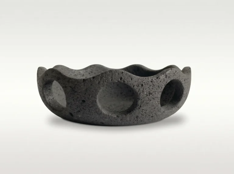 Lava Sun Bowl by Studio Ayres in dark grey porous volcanic rock, scalloped rim and round cutouts