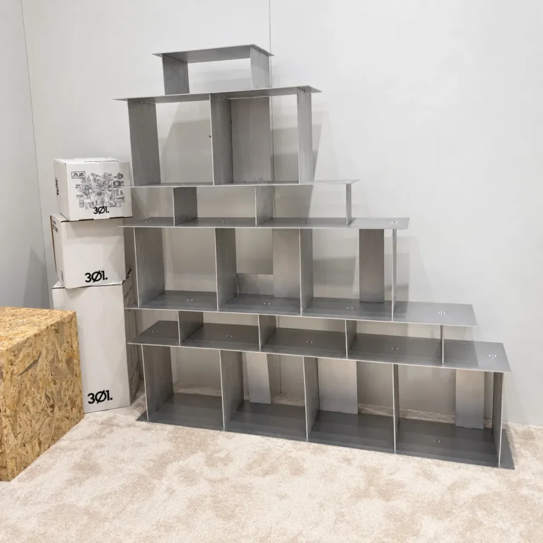 Open Grid Shelves by 301 Design Studio seen from the side, empty open compartments beside stacked boxes
