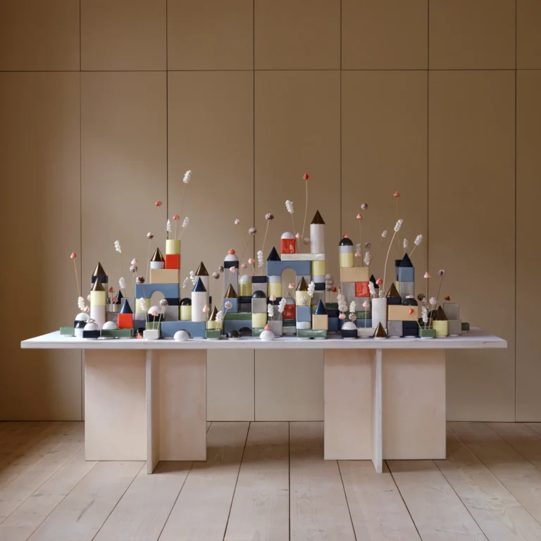 Knstrkt Set Of 14 by Studio Berg as a large city of blocks and dried flowers on a long wooden table
