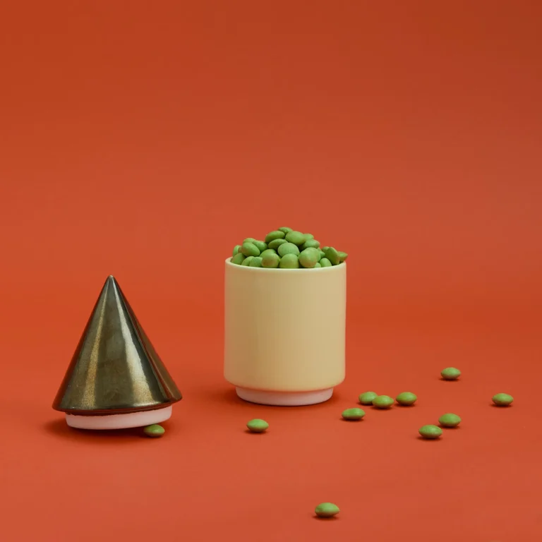 Knstrkt Set Of 2 With Large Pieces by Studio Berg, cone lid off and the cream container filled with green sweets