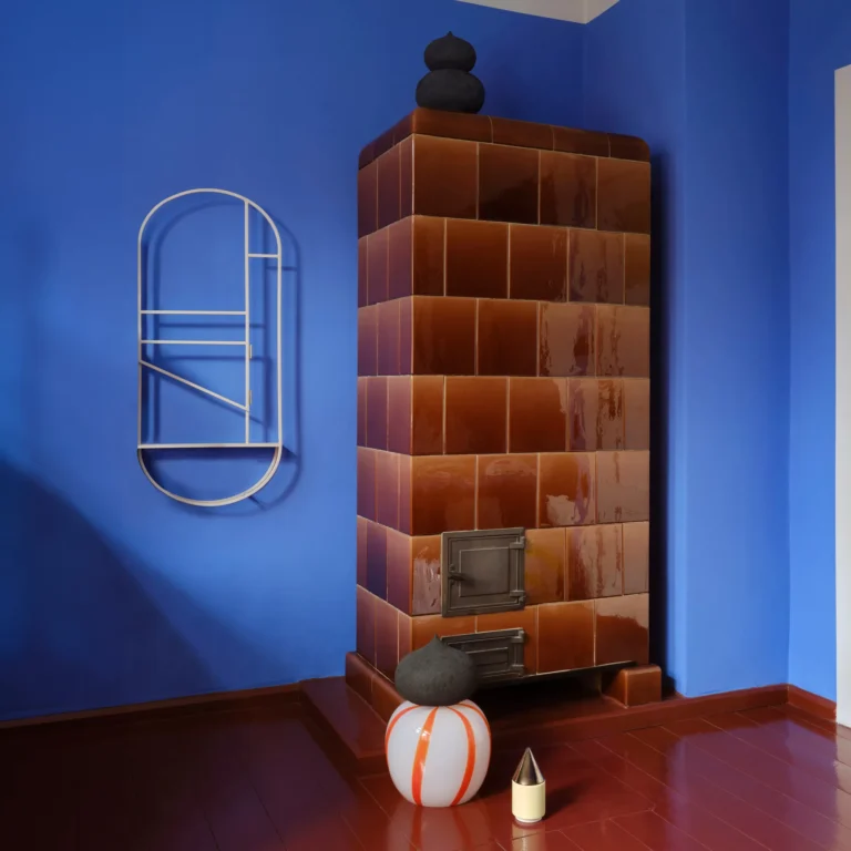 Knstrkt Set Of 2 With Large Pieces by Studio Berg on a red floor, in front of a brown tiled stove and a blue wall