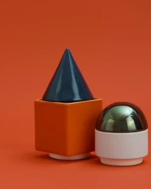 Knstrkt Set Of 4 by Studio Berg, glazed blue cone lidded orange cube and white dish with dome lid, on an orange background