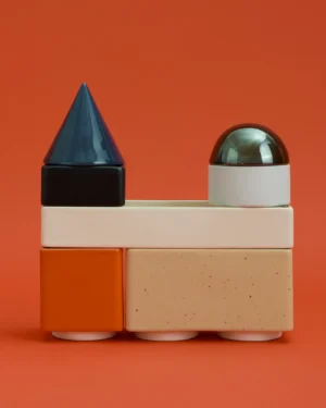 Knstrkt Set Of 7 by STUDIO BERG, stacked glazed blocks with a blue cone and silver dome, on a plain background