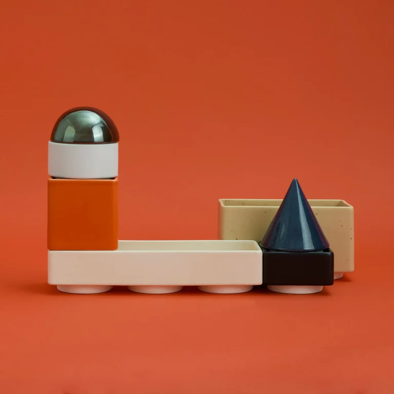 Knstrkt Set Of 7 by STUDIO BERG seen from the side, an L-shaped arrangement with the dome stacked on an orange block