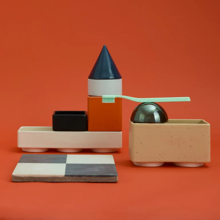 Knstrkt Set Of 7 by STUDIO BERG in a bathroom arrangement, a green toothbrush resting across the dome beside a checked tile