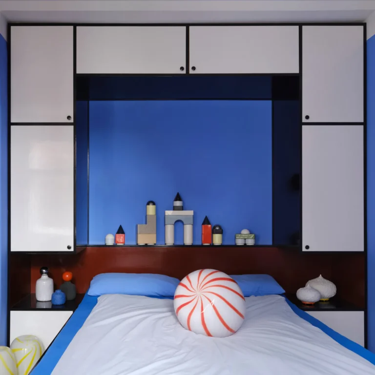 Knstrkt Set Of 14 by Studio Berg in a bedroom, small towers on a shelf in a blue alcove above a bed