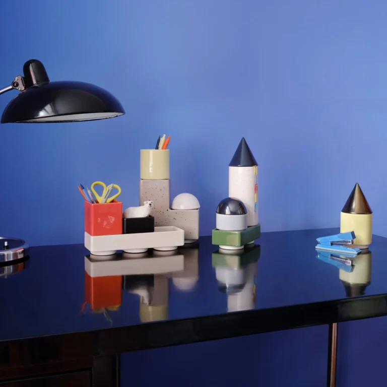 Knstrkt Set Of 14 by Studio Berg on a black desk, holding pens and scissors beside a lamp and a stapler
