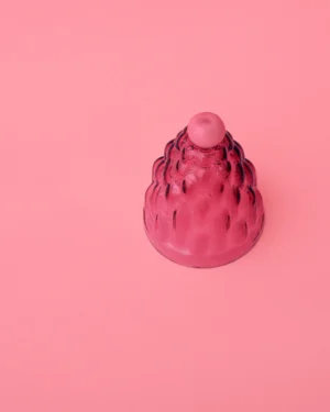 Jello High by Studio Berg seen from above, deep pink glass cloche with a ridged surface and round knob, on pink