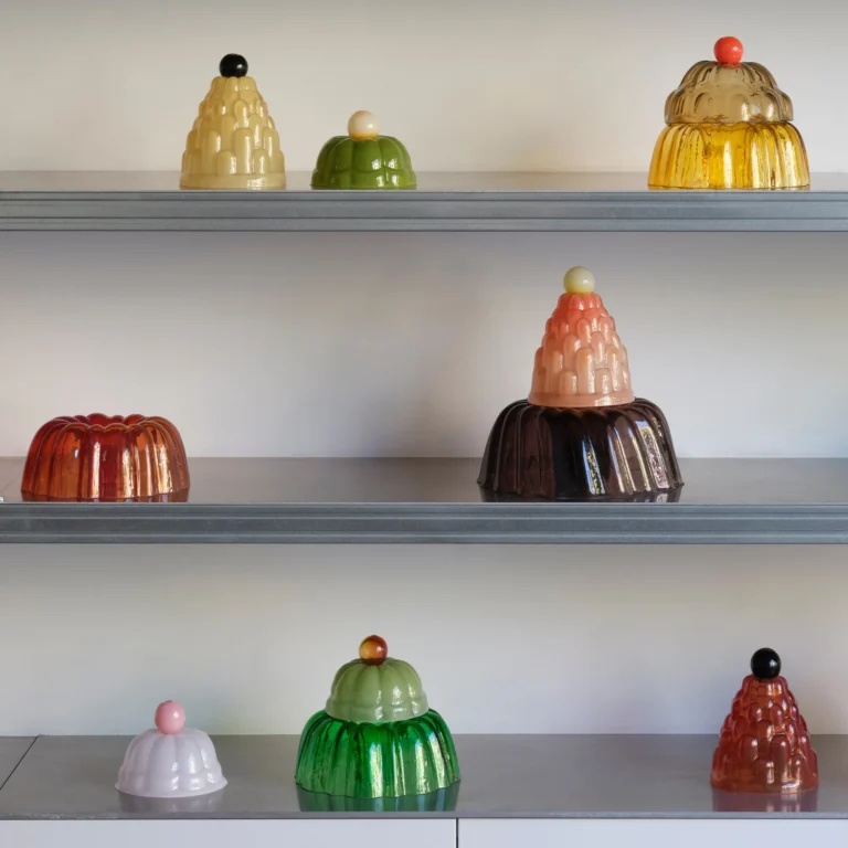 Jello High by Studio Berg on gray shelves, glass cloches in yellow, green, red and brown with round knobs