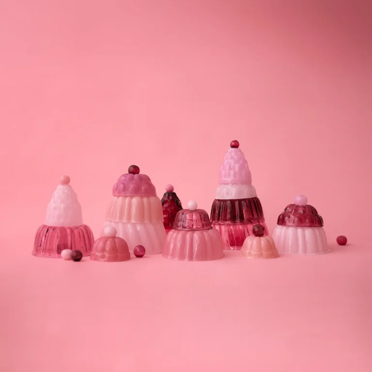 Jello High by Studio Berg shown in a group of pink and red glass cloches of several sizes, on a pink background