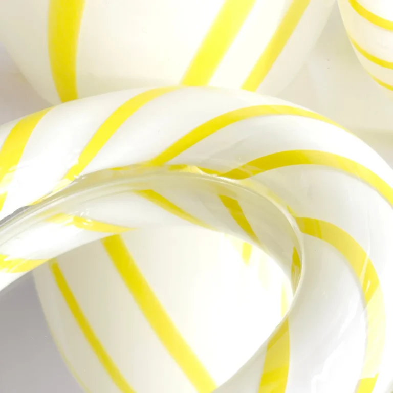 Close-up of the Yellow Candy Mirror's twisted glass frame, with glossy yellow stripes running through white and clear glass