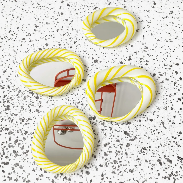 Yellow Candy Mirror by Studio Berg, four striped glass mirrors in different shapes laid on a speckled white surface