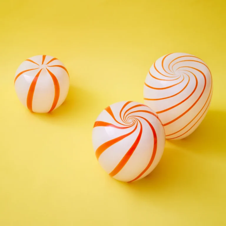 Red Candy Side Table by STUDIO BERG, three striped glass forms in different sizes with orange swirls, on yellow